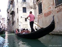 船夫摇着贡多拉穿行在威尼斯水道